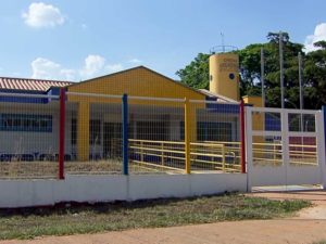 imagem mostra fachada da creche, prédio térreo colorido, com grades